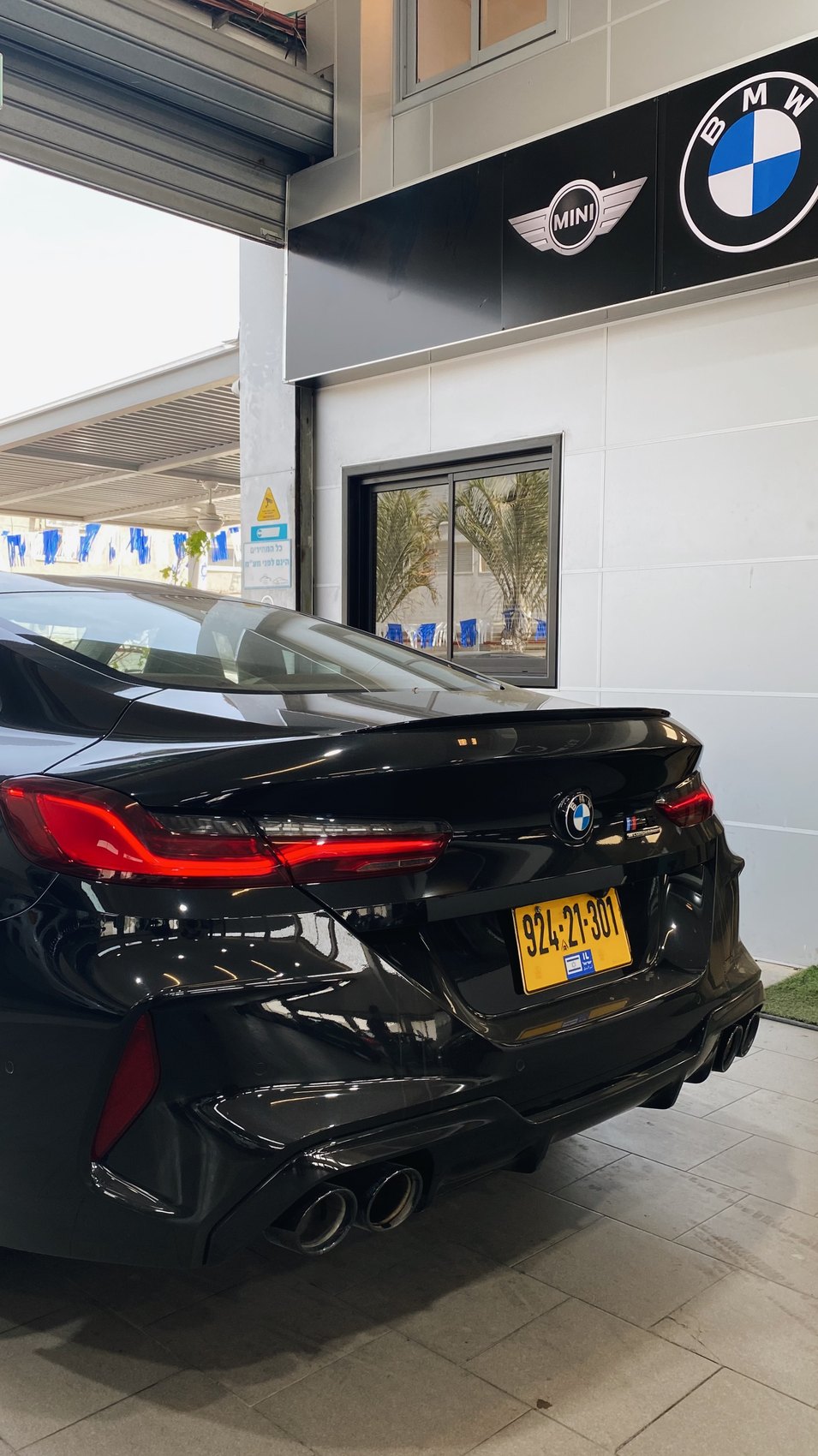 BMW M8 שחורה תחת שילוט BMWNABA במוסך